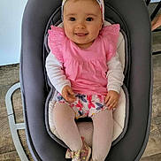 Lily a rejoint le concours — aidez-le/la à gagner de superbes lots ! baby, infant, smiling, pink_clothing, headband, baby_rocker, shoes, tights, child, cute, happy, indoor, flooring, wood_floor, seat, person, portrait, playful, home, young_child
