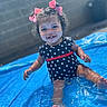 baby, blue, bows, child, curly_hair, face, feet, happy, outdoor, play, polka_dot, pool, red, sitting, smiling, splashing, sunny, swimsuit, toddler, water