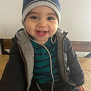 Dayan a rejoint le concours — aidez-le/la à gagner de superbes lots ! baby, beanie, blue, child, clothing, cute, face, happy, hat, indoor, jacket, person, portrait, sitting, smiling, striped, table, warm, wooden, young