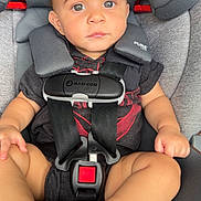 Azir is registered to the contest to win money with this photo: baby, black_clothing, car_safety, car_seat, child, cute, expression, hands, indoor, infant, legs, looking_at_camera, maxi_cosi, portrait, red_detail, safety, seatbelt, socks, straps, young_child