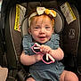 baby, child, car_seat, headband, pink_sunglasses, smile, happy, infant, blue_outfit, seatbelt, indoors, cute, young_child, person, holding, accessory, playful, closeup, adorable, skin