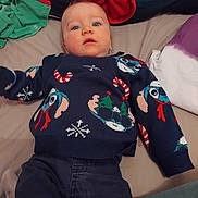 Nolan Hamy a rejoint le concours — aidez-le/la à gagner de superbes lots ! baby, bed, blanket, blue_eyes, casual, child, christmas, clothing, comfort, cute, expression, fabric, holiday, indoor, infant, laying_down, person, portrait, soft_lighting, sweater