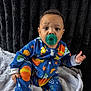Aspen And Denver is registered to the contest to win money with this photo: baby, child, pacifier, blue_clothing, onesie, space_theme, stars, planets, blanket, black_background, sitting, cute, indoors, portrait, infant, toddler, colorful, expression, soft_texture, cozy