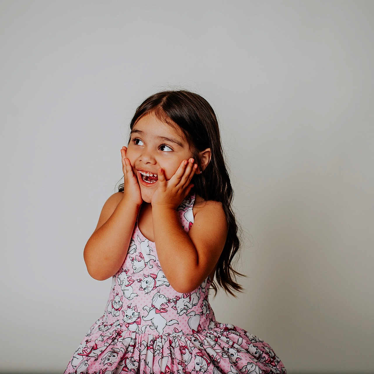 Cecilia is registered to the contest to win money with this photo: cat_pattern, cheerful, child, cute, expression, fashion, girl, hands_on_face, happy, innocence, joyful, long_hair, neutral_background, pink_dress, playful, portrait, sleeveless_dress, smiling, studio, young