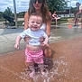 Liam joined the competition — help win amazing prizes! child, toddler, woman, water_fountain, splash, outdoor, park, summer, play, water, sunlight, happy, sunglasses, casual_clothing, concrete, bench, grass, people, family, fun