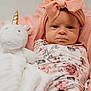 baby, infant, headband, bow, pink, floral_outfit, plush_toy, unicorn, blanket, soft_toy, cute, portrait, indoors, child, face, expression, newborn, cozy, resting, person