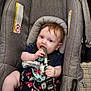 Briella is registered to the contest to win money with this photo: baby, car_seat, infant, child, chewing, packaging, blue_eyes, floral_dress, shopping_cart, foot, hand, seatbelt, gray_fabric, curious, indoor, person, cute, young_child, retail, product