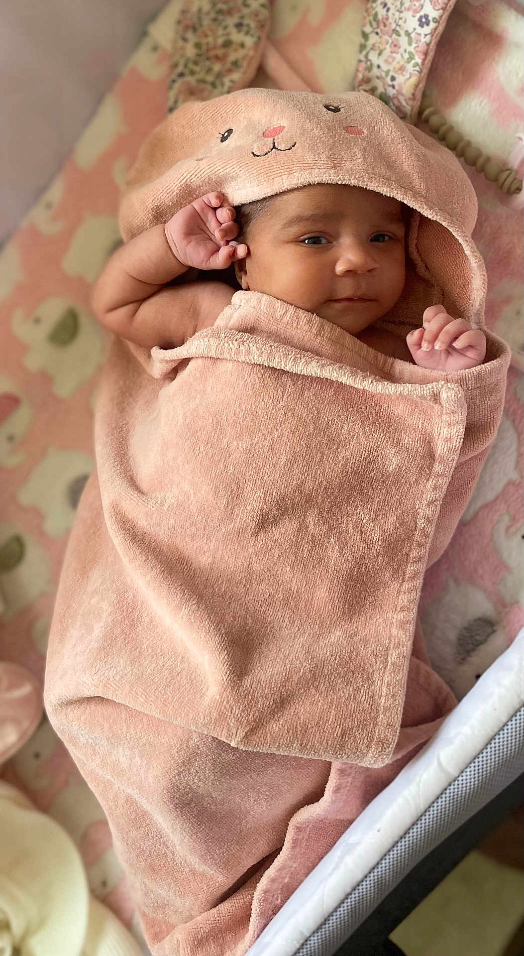 Charlotte is registered to the contest to win money with this photo: baby, towel, pink, blanket, elephant_pattern, hood, cute, face, infant, wrapped, soft, cozy, hands, lying_down, indoor, child, portrait, newborn, expression, cute_outfit