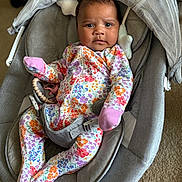 Charlotte joined the competition — help win amazing prizes! baby, infant, onesie, floral_pattern, baby_rocker, car_seat, gray, soft_fabric, indoor, carpet, child, person, newborn, cute, face, expression, sitting, comfortable, toy, pink_mittens