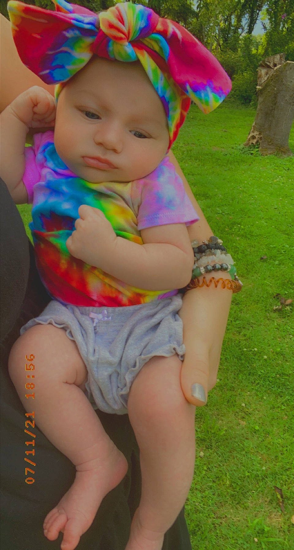 Aura is registered to the contest to win money with this photo: baby, baby_toddler_clothing, eye, face, facial_expression, fun, grass, green, happy, hat, head, headwear, human_body, leg, people_in_nature, person, pink, plant, skin, thigh