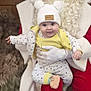 baby, child, hat, pom_pom, clothing, gloves, person, face, smile, indoor, festive, holiday, santa_claus, red_clothing, white_gloves, cute, warm, winter, infant, holding