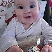 Ashley joined the competition — help win amazing prizes! baby, child, infant, toy, hand, face, eyes, cheeks, clothing, pillow, reindeer, patterned, cozy, indoor, cute, smiling, closeup, soft, plush, holiday