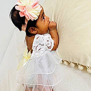 Jeevithapriya is registered to the contest to win money with this photo: baby, infant, child, dress, lace, flower_headband, thumb_sucking, cute, soft_texture, cream_color, lying_down, small_feet, curious, indoors, portrait, adorable, toddler, sleepy, closeup, gentle