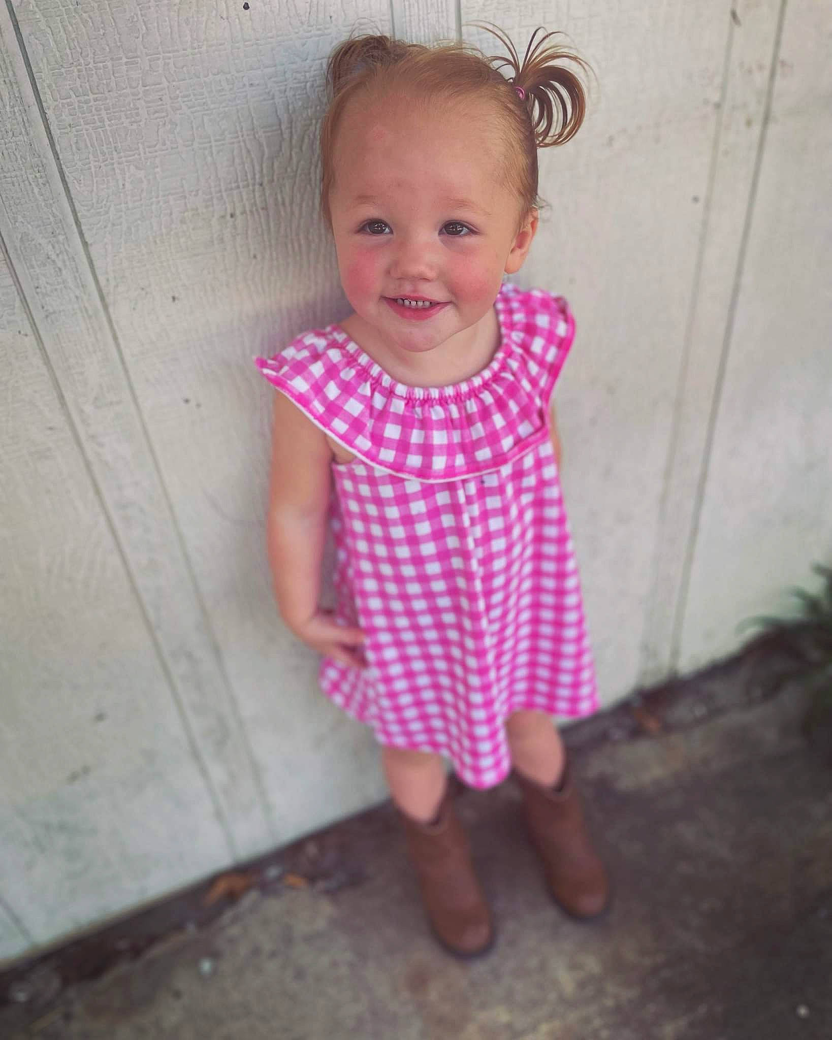 Avrianna is registered to the contest to win money with this photo: baby_toddler_clothing, child, face, flooring, foot, fun, grass, hand, happy, joy, leg, magenta, pattern, person, pink, plant, sandal, sleeve, smile, t_shirt