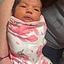 newborn, baby, swaddled, blanket, floral_pattern, pink, white, infant, arm, tattoo, heart, human_hand, closeup, portrait, resting, soft_lighting, indoor, person, cute, young