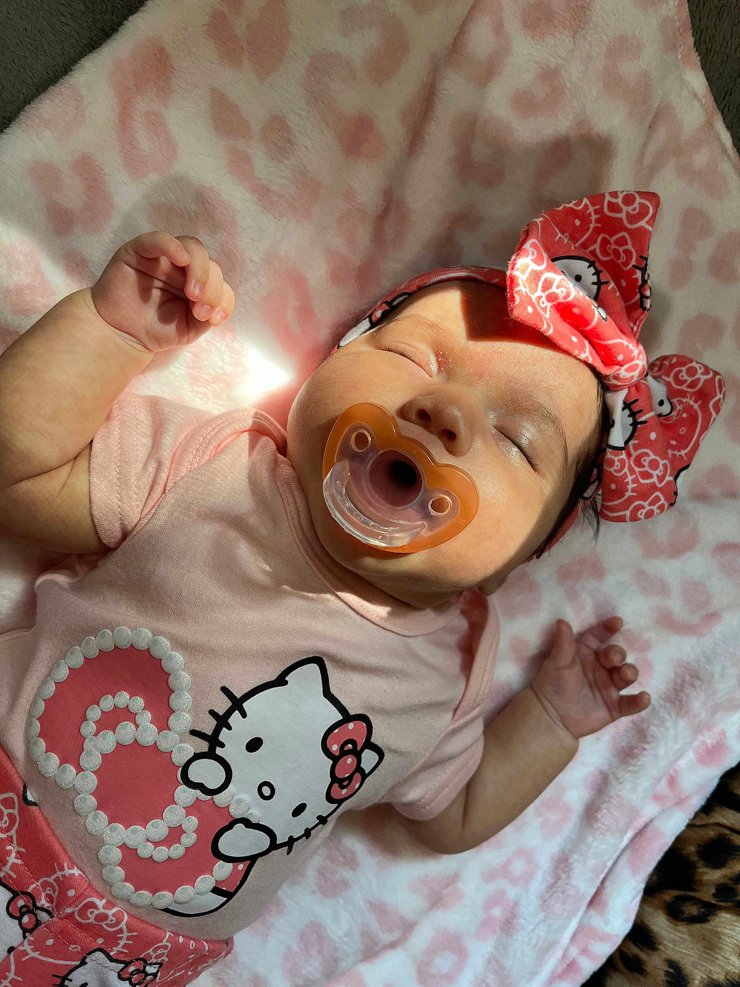 Lysandra is registered to the contest to win money with this photo: baby, sleeping, pacifier, hello_kitty, headband, pink, blanket, heart_pattern, infant, cute, child, apparel, soft_texture, nap, resting, adorable, peaceful, clothing, toddler, indoor