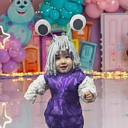 Chloe joined the competition — help win amazing prizes! alien, antennae, background_characters, balloons, celebration, child, colorful, costume, cute, decorations, festive, floor_reflection, fun, googly_eyes, indoor, party, playful, purple_dress, smiling, toddler