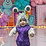 toddler, child, costume, alien, googly_eyes, antennae, purple_dress, balloons, party, decorations, colorful, indoor, smiling, cute, playful, floor_reflection, celebration, background_characters, festive, fun