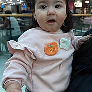 Chloe is registered to the contest to win money with this photo: baby, casual_clothing, child, curious, cute, expression, face, fashion, ghost_patch, hands, holding, indoor, long_hair, people, person, pink_bow, pink_sweatshirt, pumpkin_patch, shopping_mall, toddler