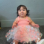 Chloe joined the competition — help win amazing prizes! baby, child, girl, dress, pink, butterflies, carpet, white_shoes, bows, indoor, portrait, cute, smiling, happy, sitting, hair_clip, curly_hair, wall, floor, young
