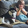 dog, husky, child, girl, couch, indoor, smile, happy, pet, animal, furniture, beads, ears, clothing, playful, cute, friendship, home, relax, portrait