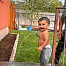 Christopher is registered to the contest to win money with this photo: child, toddler, water, hose, grass, backyard, tree, fence, smile, barefoot, shirtless, pants, adult, person, play, summer, outdoor, garden, concrete, happy