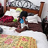 Landon is registered to the contest to win money with this photo: baby, bed, bib, blanket, cap, child, colorful, cozy, decor, fabric, foot, hand, headboard, headphones, indoor, person, pillow, sitting, toy, wood