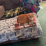 cat, orange_cat, blanket, couch, throw_blanket, folded_blanket, indoor, living_room, carpet, curtains, window_light, cozy, furniture, pet, resting, domestic, home, fabric, patterned, relaxing