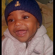 Andre is registered to the contest to win money with this photo: baby, child, smiling, face, hat, beanie, clothing, fleece, jacket, portrait, happy, cute, warm, indoor, closeup, person, infant, apparel, headwear, earring