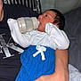 Noah is registered to the contest to win money with this photo: baby, newborn, infant, feeding, bottle, blue_pants, white_onesie, adult_arm, calvin_klein, black_shirt, hand, face, hair, indoor, cozy, sleepwear, portrait, human, child, care
