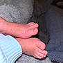 baby_feet, close_up, soft_texture, blanket, blue_sleeve, skin_detail, toes, infant, cozy, warm, resting, small, cute, sleeping_baby, newborn, fuzzy, comfort, indoor, peaceful, tender