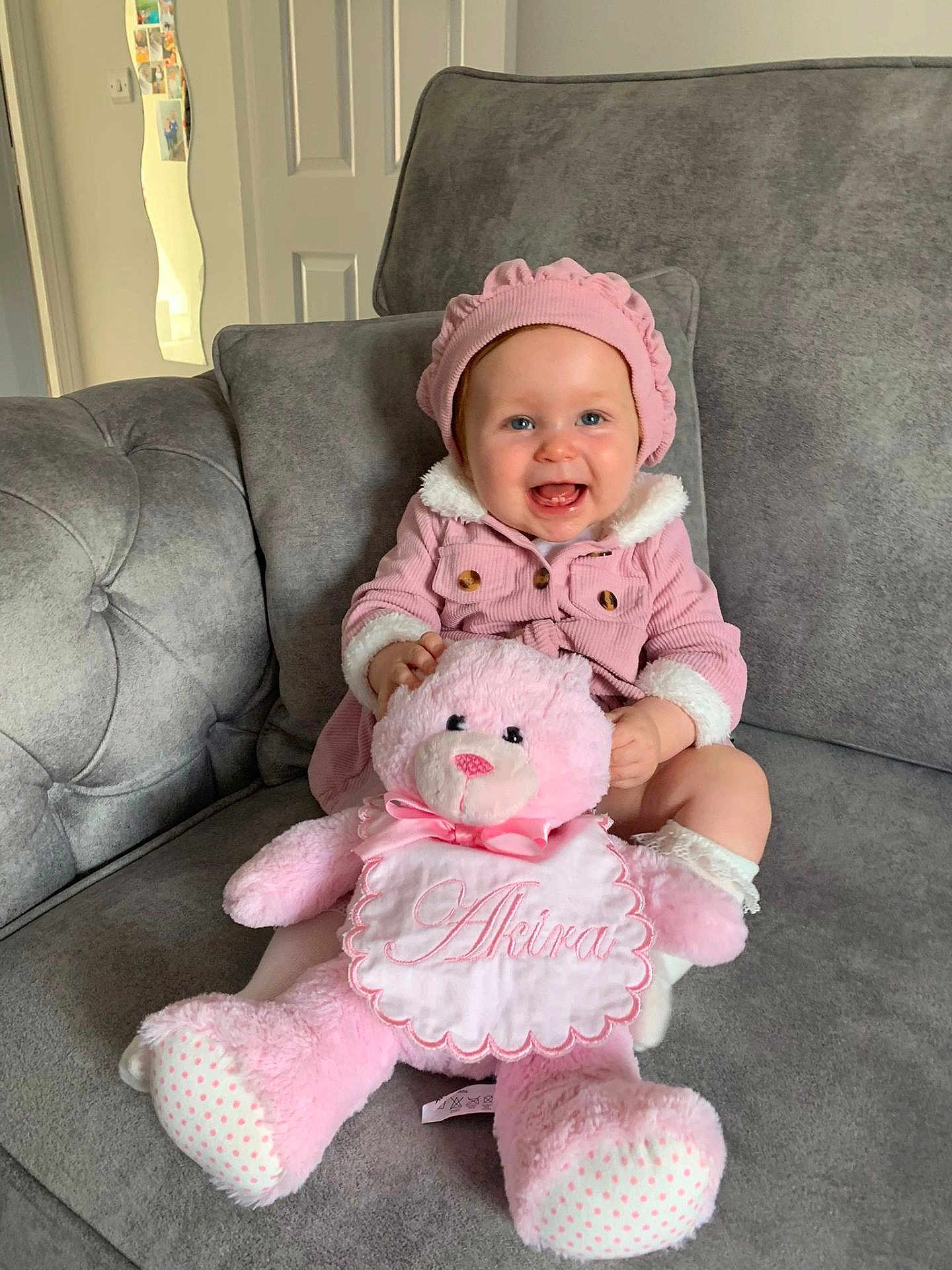 Akira joined the competition — help win amazing prizes! baby, pink_outfit, pink_hat, teddy_bear, smiling, sitting, couch, indoor, child, plush_toy, happy, cute, portrait, furniture, home, cozy, infant, soft_toy, clothing, person