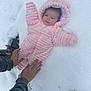 baby, infant, pink_suit, snow, winter_clothing, outdoors, hands, cold_weather, cute, child, warm, snowy_ground, hooded_jacket, footwear, person, lying_down, winter, protection, small_child, fluffy