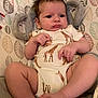 Rayleigh is registered to the contest to win money with this photo: baby, infant, onesie, giraffe_pattern, plush, elephant_headrest, cushion, leaf_pattern, soft_fabric, child, cute, portrait, indoor, skin, face, hand, foot, expression, comfort, relaxation