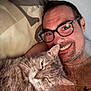 Fanette a rejoint le concours — aidez-le/la à gagner de superbes lots ! animal, bed, cat, chain_necklace, closeup, facial_hair, glasses, gray_cat, happy, human, indoor, man, pet, pillow, portrait, relaxed, resting, smiling, snuggling, tattoo