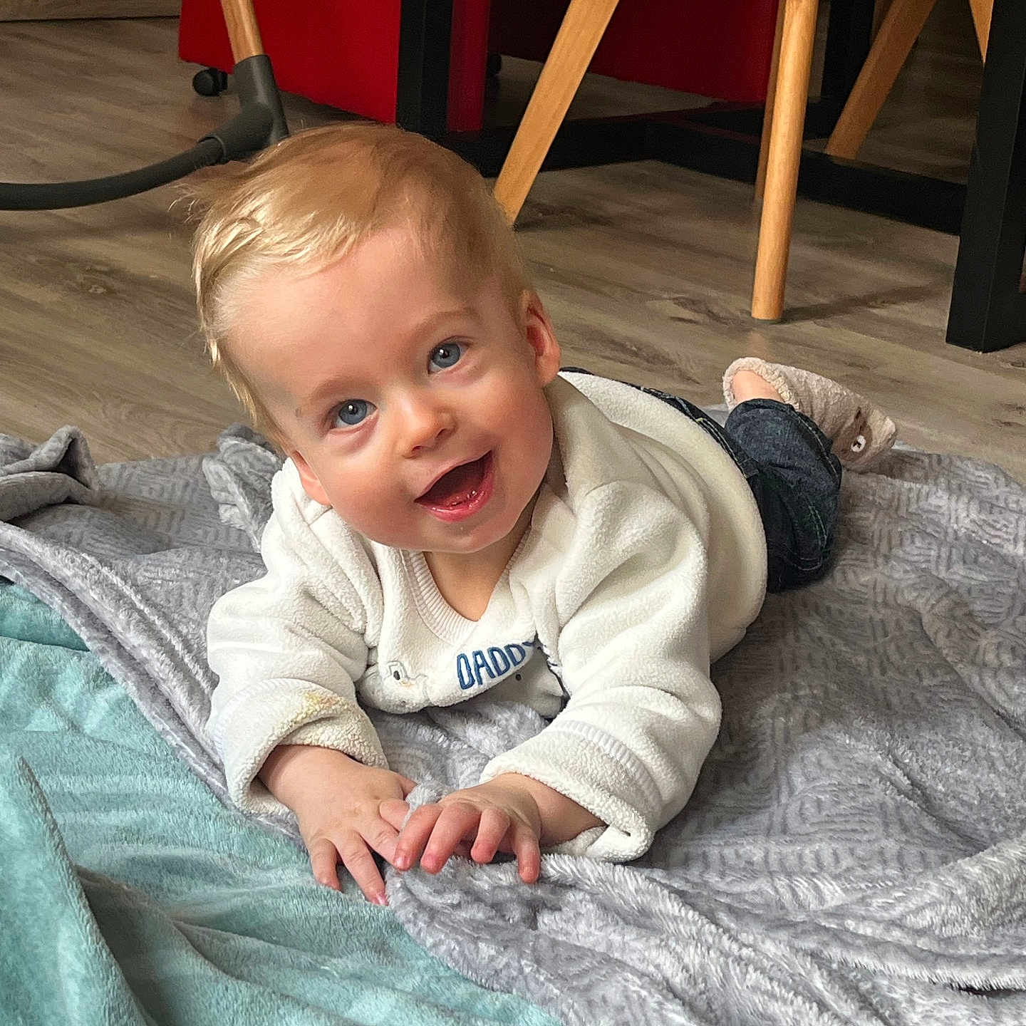 Thyméo a rejoint le concours — aidez-le/la à gagner de superbes lots ! baby, babylaughing, blanket, blonde, clothing, crawling, face, footwear, furniture, happy, head, jeans, pants, person, photography, portrait, quilt, shoe, sitting, smile