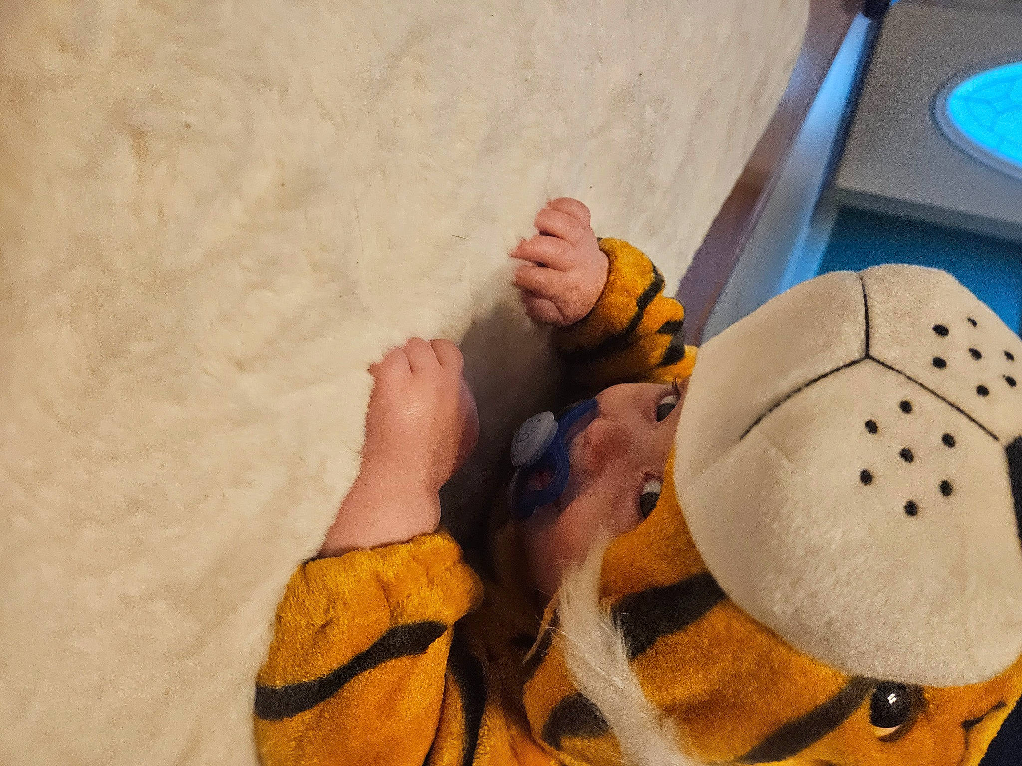 Ezra is registered to the contest to win money with this photo: cap, child, fashion_accessory, finger, flooring, fun, glove, hat, helmet, human_leg, nail, person, personal_protective_equipment, plush, recreation, sports_gear, stuffed_toy, textile, toy, wood