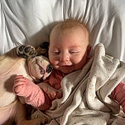 Layla is registered to the contest to win money with this photo: baby, puppy, blanket, bed, sleeping, cuddling, cute, infant, pet, animal, child, resting, soft, warm, comfort, pink_clothing, white_bed, polka_dot, snuggling, adorable