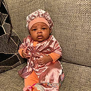 Heaven joined the competition — help win amazing prizes! baby, infant, child, pink_clothing, bonnet, pacifier, sitting, couch, fabric, texture, cute, indoors, portrait, expression, soft_lighting, hand, footwear, person, home, relaxed