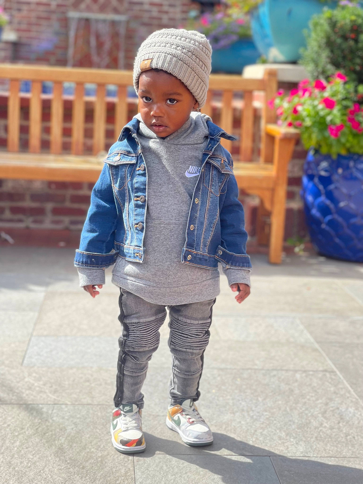 Ej is registered to the contest to win money with this photo: cap, child, denim, electric_blue, facial_expression, flowerpot, fun, happy, headwear, jacket, knit_cap, leisure, outerwear, pattern, person, plant, recreation, sleeve, street, street_fashion