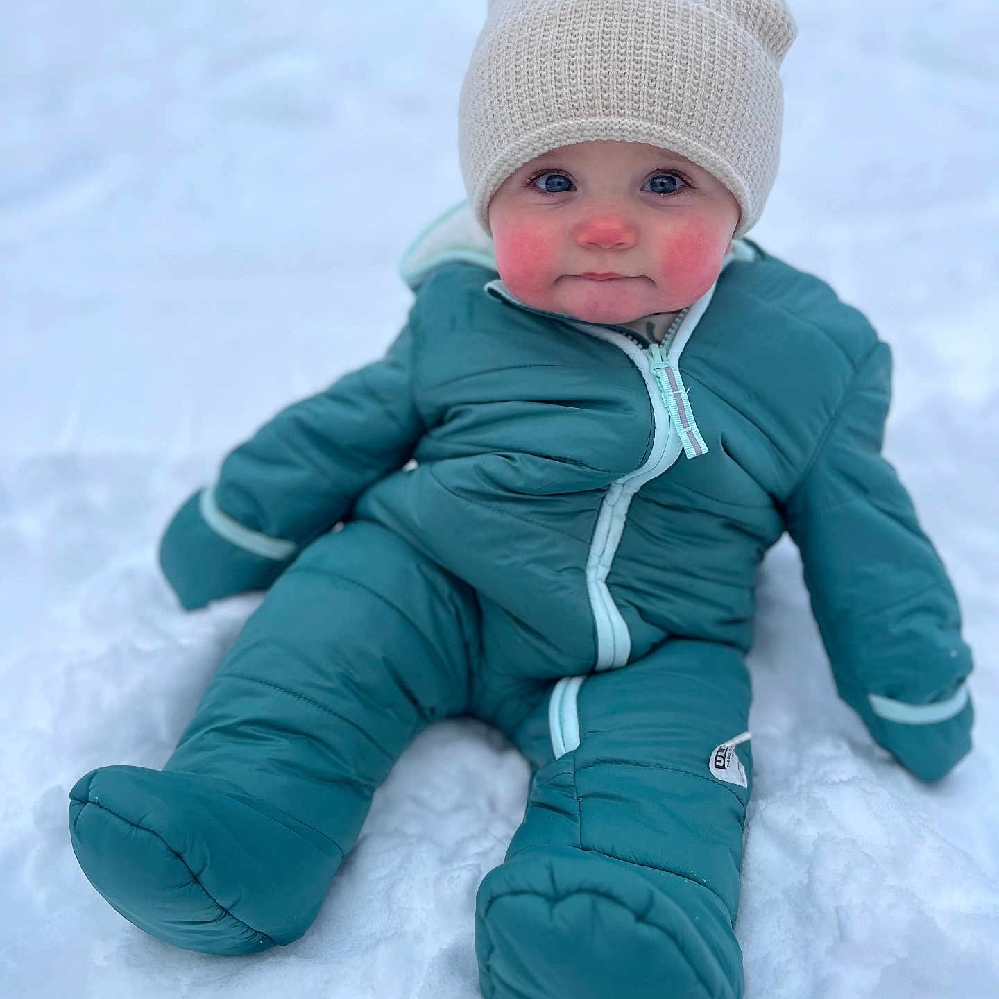Emery is registered to the contest to win money with this photo: baby, blue_eyes, child, cold_weather, cute, frozen, infant, knit_hat, outdoor, playful, portrait, rosy_cheeks, sitting, snow, snowsuit, soft_texture, warm, winter, winter_clothing, young_child