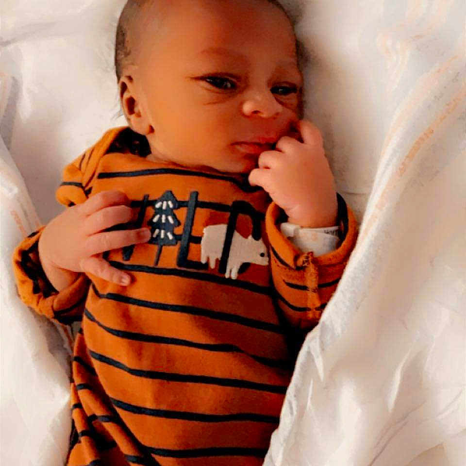 Kingston is registered to the contest to win money with this photo: baby, bed, blanket, bodypart, cradle, crib, cushion, face, finger, furniture, hand, happy, head, infantbed, newborn, person, photography, portrait, sleeping, smile