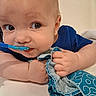 Tatem is registered to the contest to win money with this photo: baby, blue_shirt, chewing, child, close_up, cloth, cute, expression, eyes, face, food, hand, indoor, infant, mouth, person, playful, skin, spoon, young
