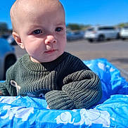 Tatem joined the competition — help win amazing prizes! baby, blue_sky, child, clothing, curious, cute, daylight, elephant_pattern, expression, face, green_sweater, infant, knitwear, outdoor, parking_lot, person, portrait, shopping_cart, soft_light, young_child