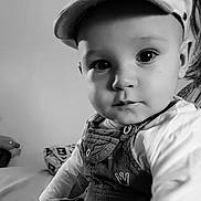 Lizio participe au concours pour gagner de l'argent avec cette photo : baby, child, infant, cap, overalls, portrait, black_and_white, indoor, cute, face, eyes, clothing, sitting, person, young, baby_clothes, headwear, closeup, curious, soft_light