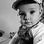 baby, child, infant, cap, overalls, portrait, black_and_white, indoor, cute, face, eyes, clothing, sitting, person, young, baby_clothes, headwear, closeup, curious, soft_light