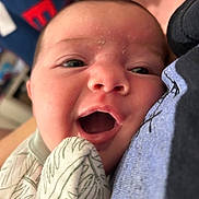 Lilah is registered to the contest to win money with this photo: baby, close_up, face, open_mouth, blanket, patterned_clothing, infant, cute, skin, head, expression, eyes, cheeks, person, newborn, soft_lighting, indoor, cozy, snuggle, portrait