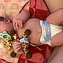 Lilah joined the competition — help win amazing prizes! baby, infant, diaper, pacifier, plush_toy, giraffe, blanket, rainbow_pattern, hand, foot, skin, cute, lying_down, child, soft_toy, comfort, sleepy, nap, indoors, young