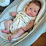Sienna is registered to the contest to win money with this photo: baby, baby_seat, blue_eyes, cherry_pattern, child, clothing, colorful, cute, face, foot, hair, hand, indoor, infant, person, relaxing, seat, soft_fabric, toy, wood_floor