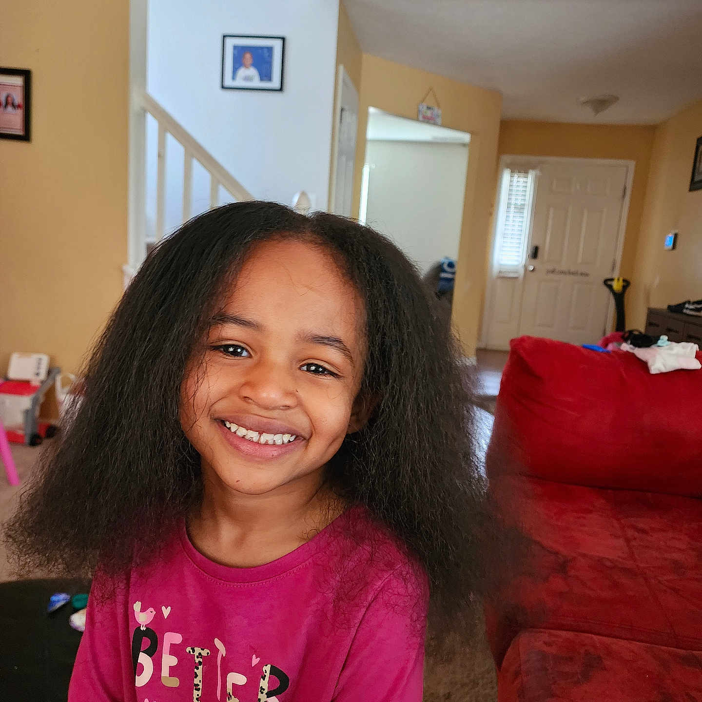 Ares joined the competition — help win amazing prizes! carpet, casual_clothing, child, cozy, door, framed_pictures, furniture, girl, happy, home, indoors, living_room, long_hair, person, portrait, red_couch, smiling, stairs, window, young